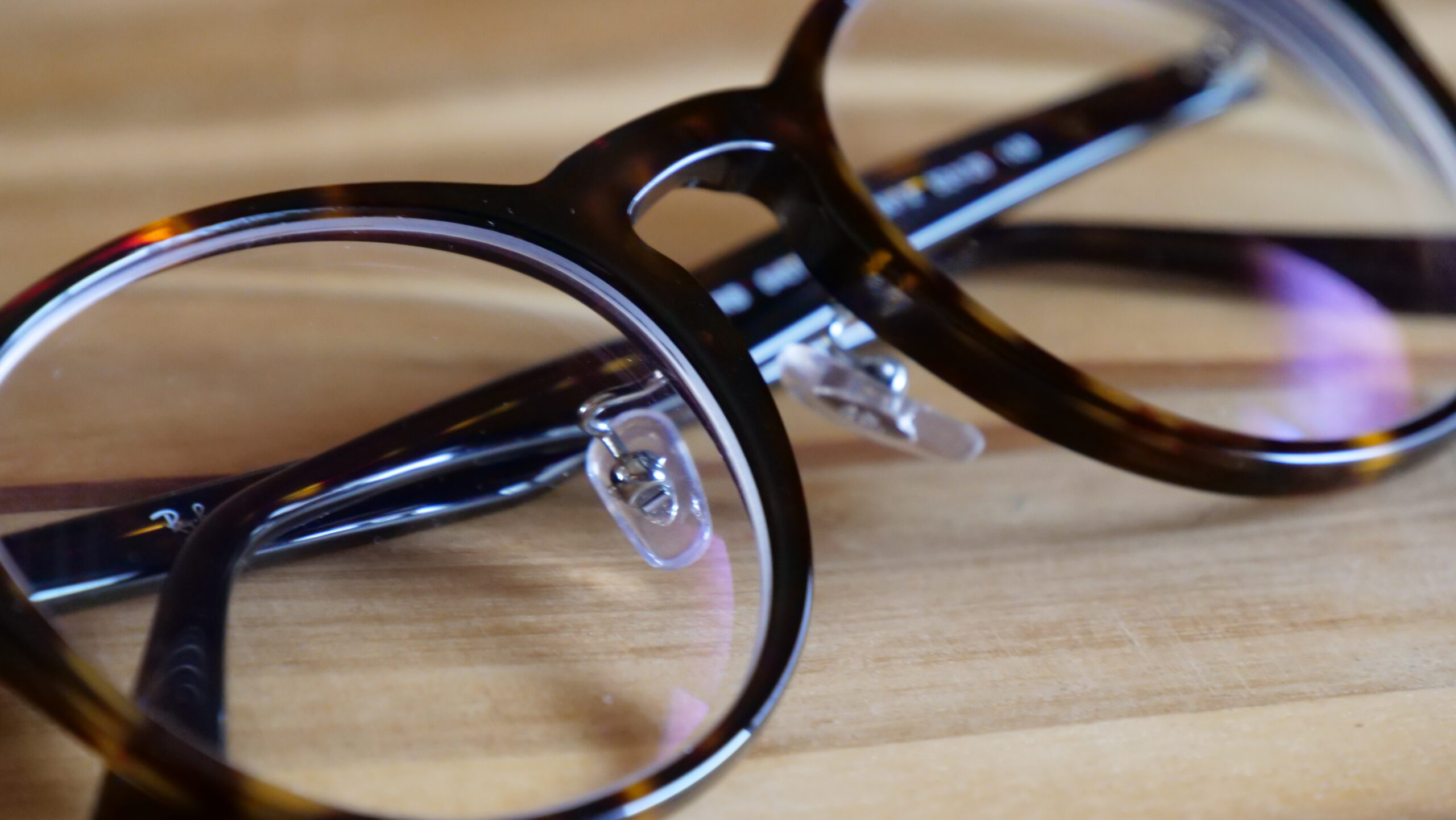茶色いボストン型メガネを机の上で撮りクローズアップした写真