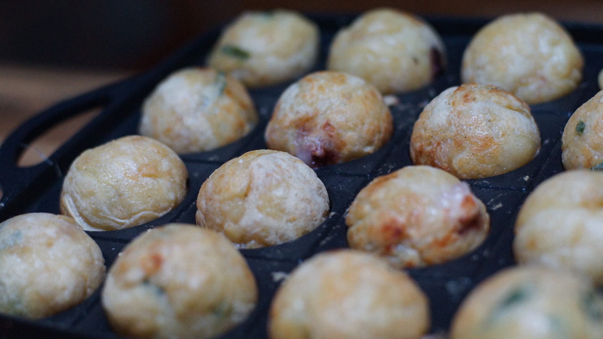 タコ焼き機でたこ焼きが丸まっている写真