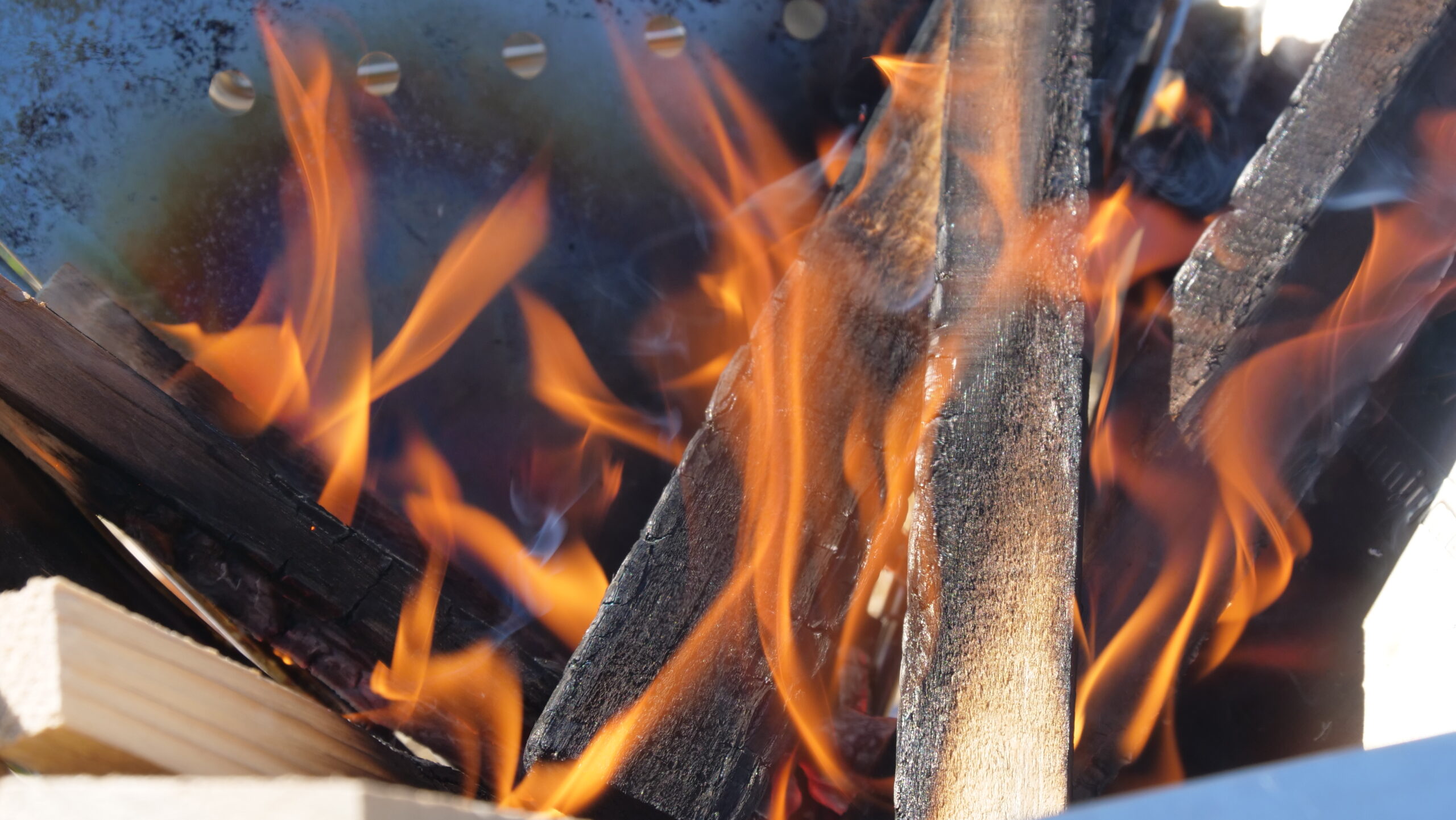 木材を燃やす焚火をしていて炎が出て木材が焦げている写真2