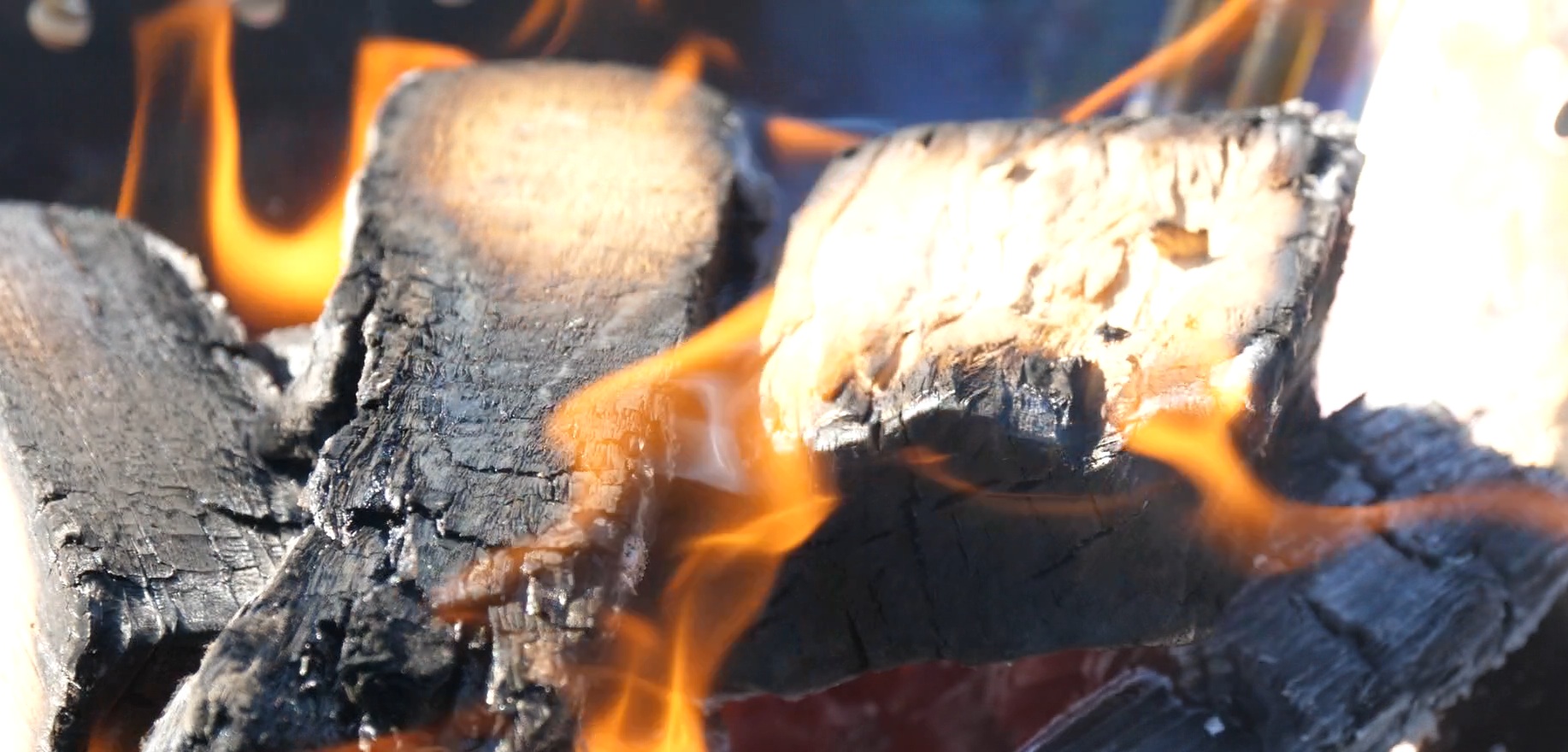木材を燃やし焚火をしていて炎が出て木材が焦げている動画《6秒》