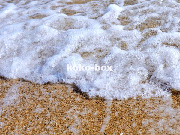 綺麗な砂浜に打ち寄せる波の躍動感のあるアップの写真