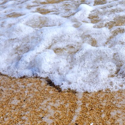 綺麗な砂浜に打ち寄せる波の躍動感のあるアップの写真