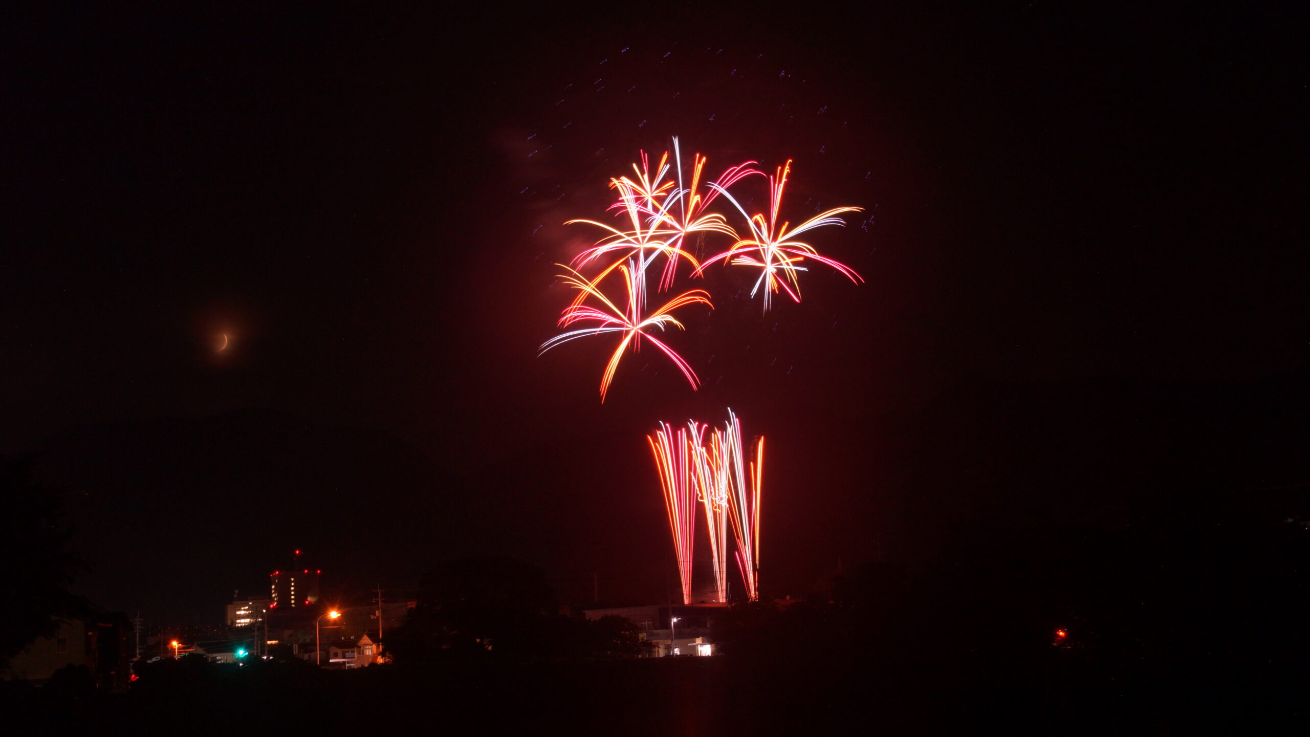 3つ打ちあがった綺麗な様々な色の花火の写真
