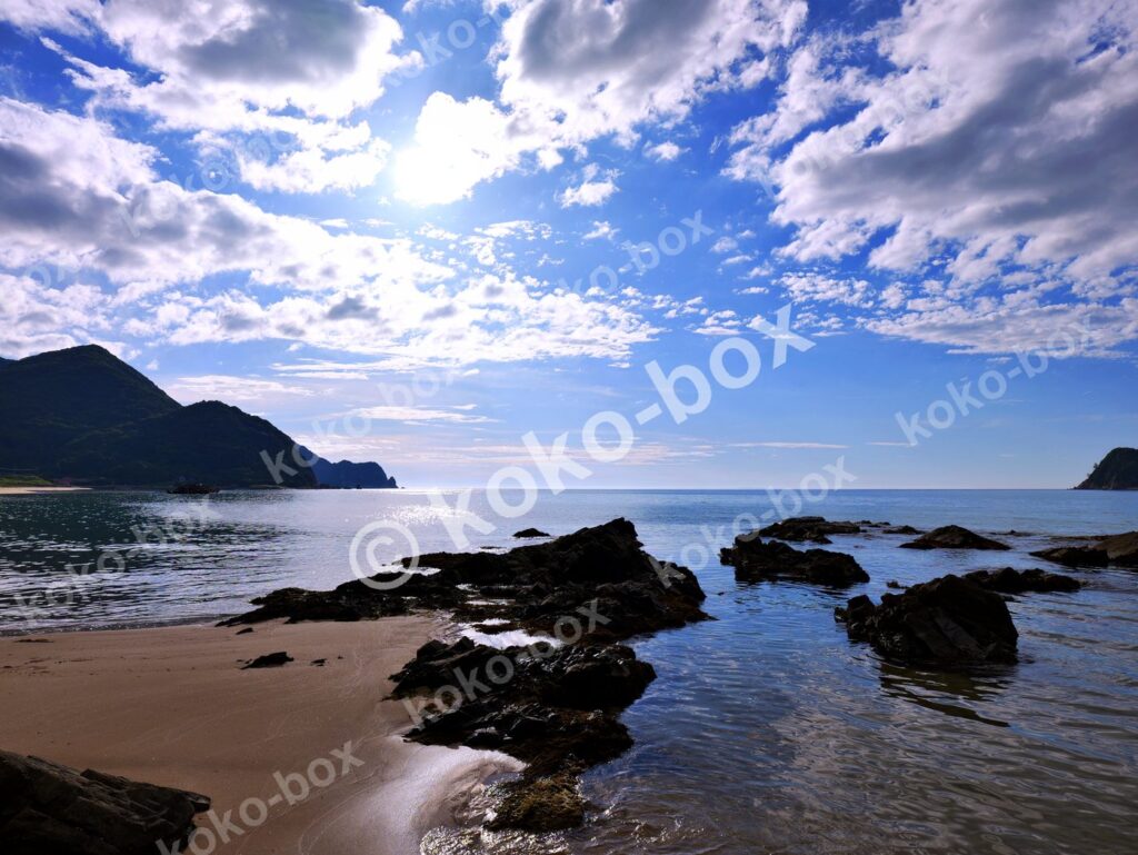 輝く陽光と岩礁の海岸風景 横位置 写真素材
