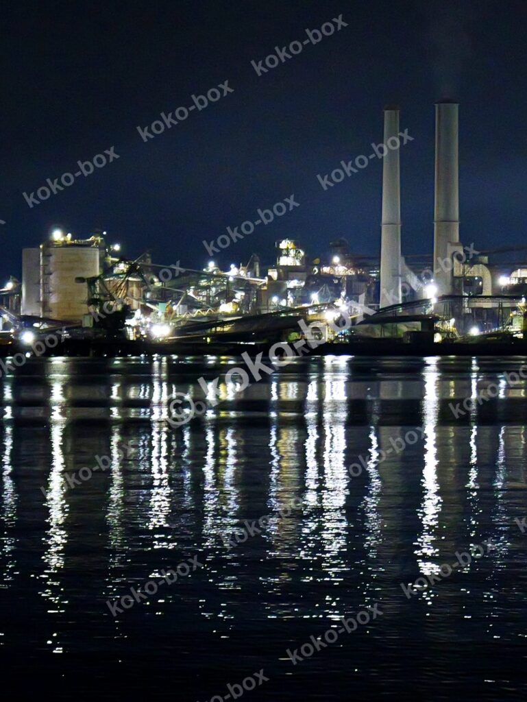幻想的な工場夜景と水面反射 縦位置写真素材