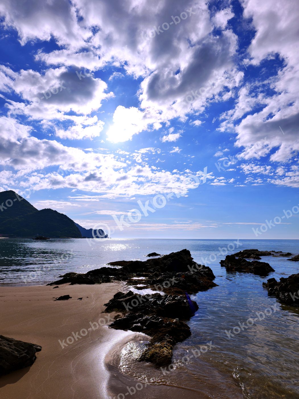 晴天の海岸と岩場 爽快な風景 縦位置写真素材