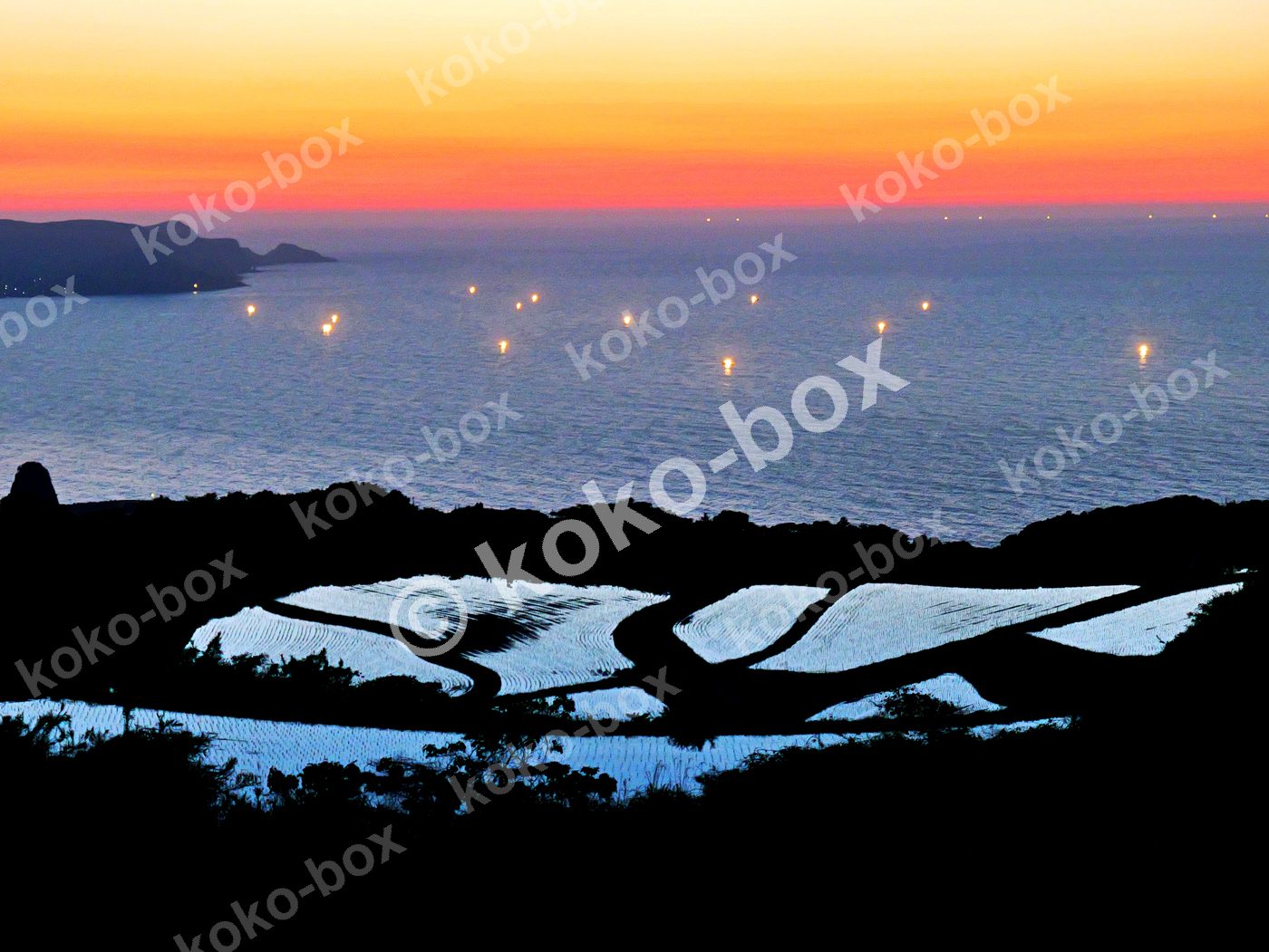 夕暮れの棚田と海に浮かぶ漁火 横位置 写真素材
