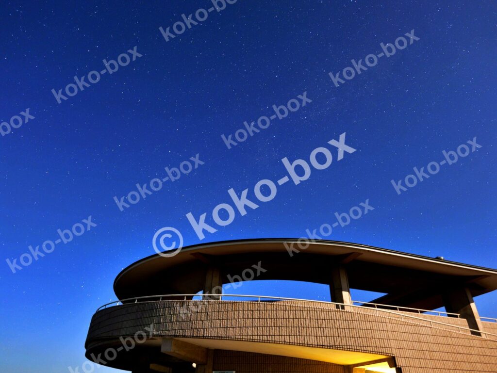 満天の星空と近代建築のカーブ 横位置 写真素材