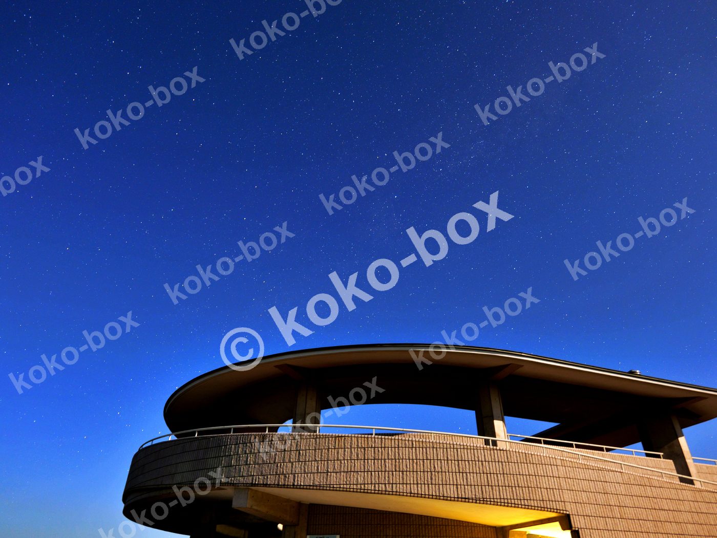 満天の星空と近代建築のカーブ 横位置 写真素材