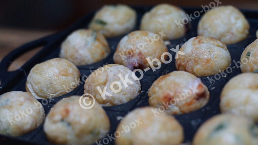 たこ焼き機で丸まるたこ焼きの調理風景 横位置 写真素材