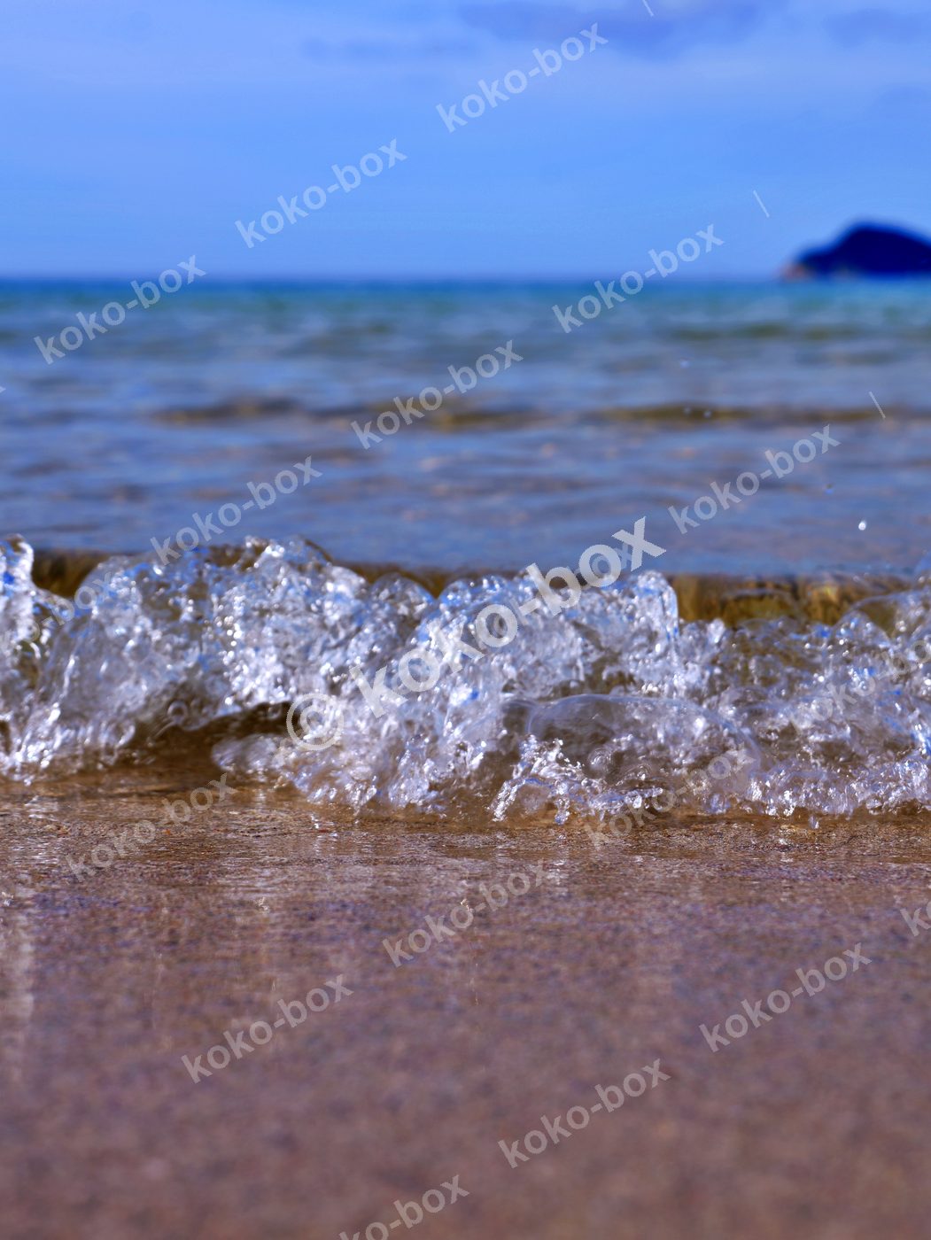 海辺の静かな波しぶきと煌めき 縦位置 写真素材