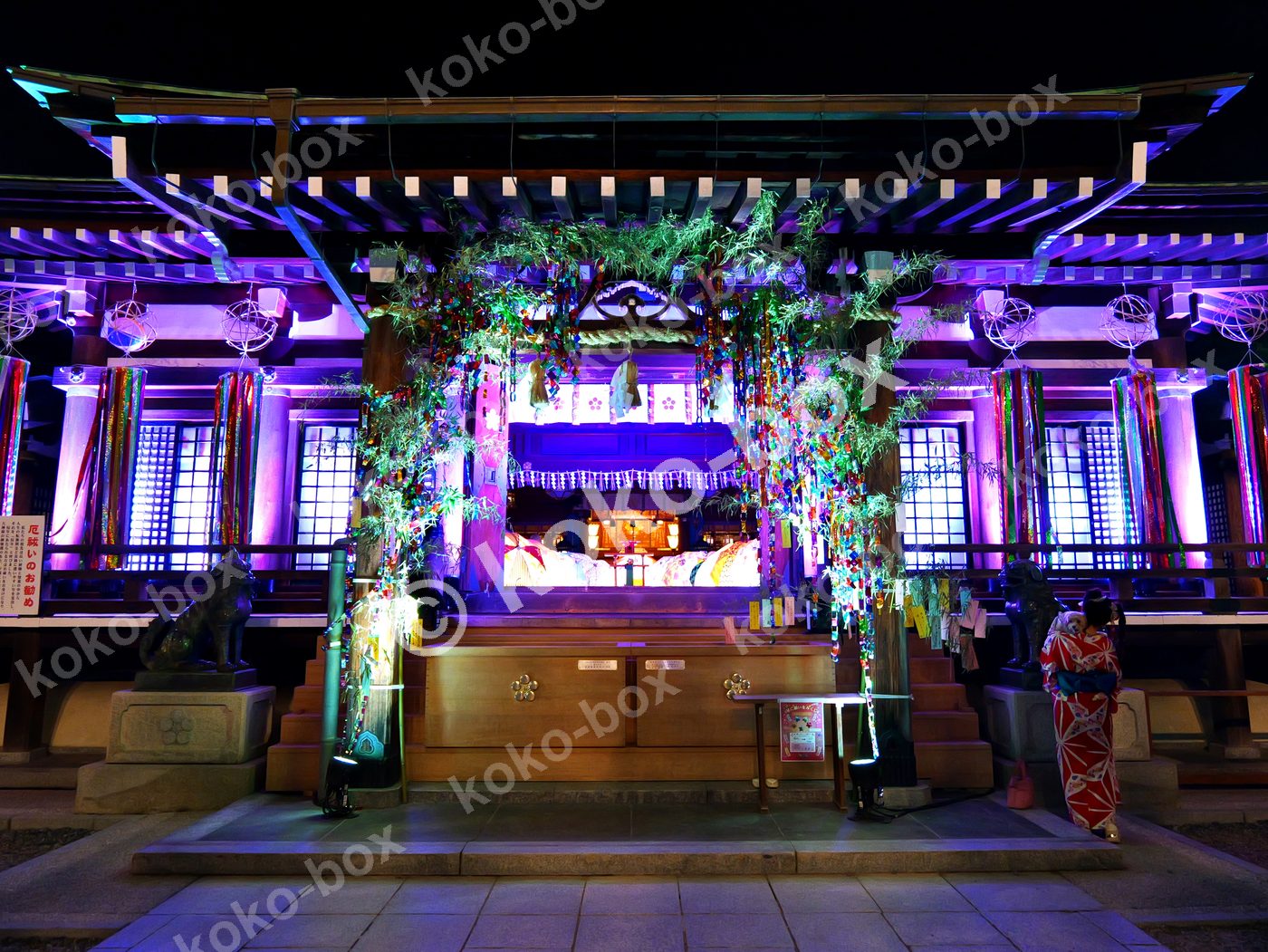 ライトアップされた夜の神社七夕飾りと女性 横位置