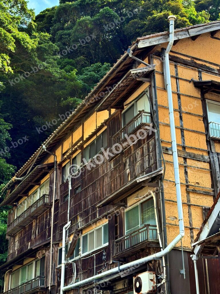 森の中の老舗温泉旅館と配管 縦位置写真