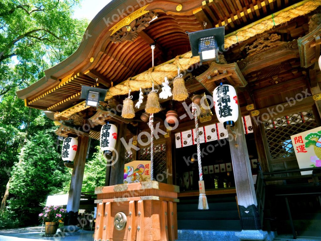 新緑の杜に佇む荘厳な神社拝殿、しめ縄と提灯（横位置）