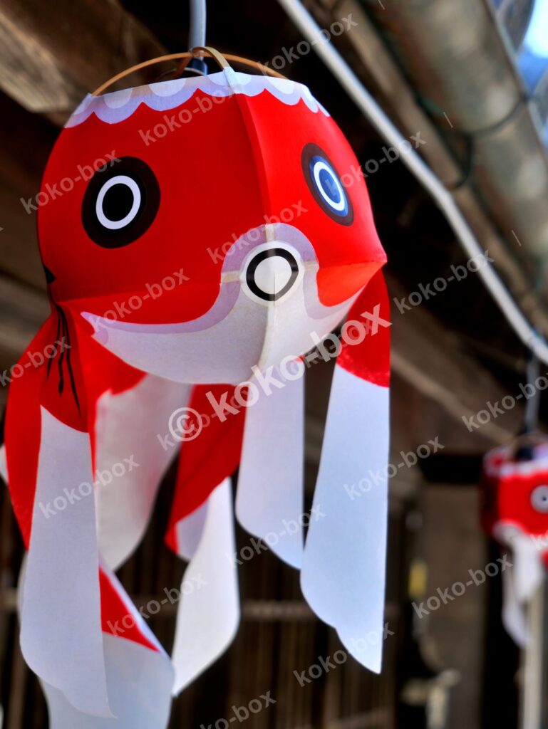 軒先に吊るされた金魚ちょうちんの縦位置写真