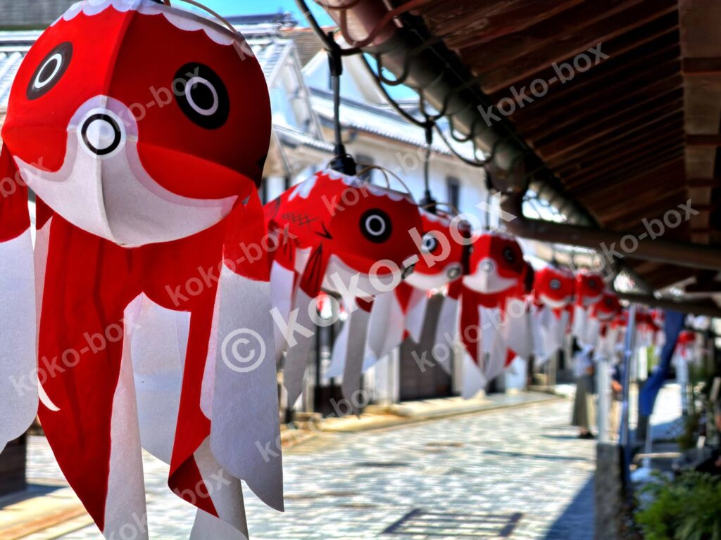 柳井の白壁の街並みに飾られた無数の金魚ちょうちんの横位置写真