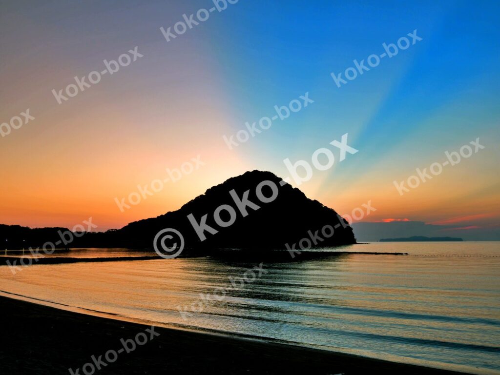 朝焼けの海に浮かぶ島のシルエット 横位置写真