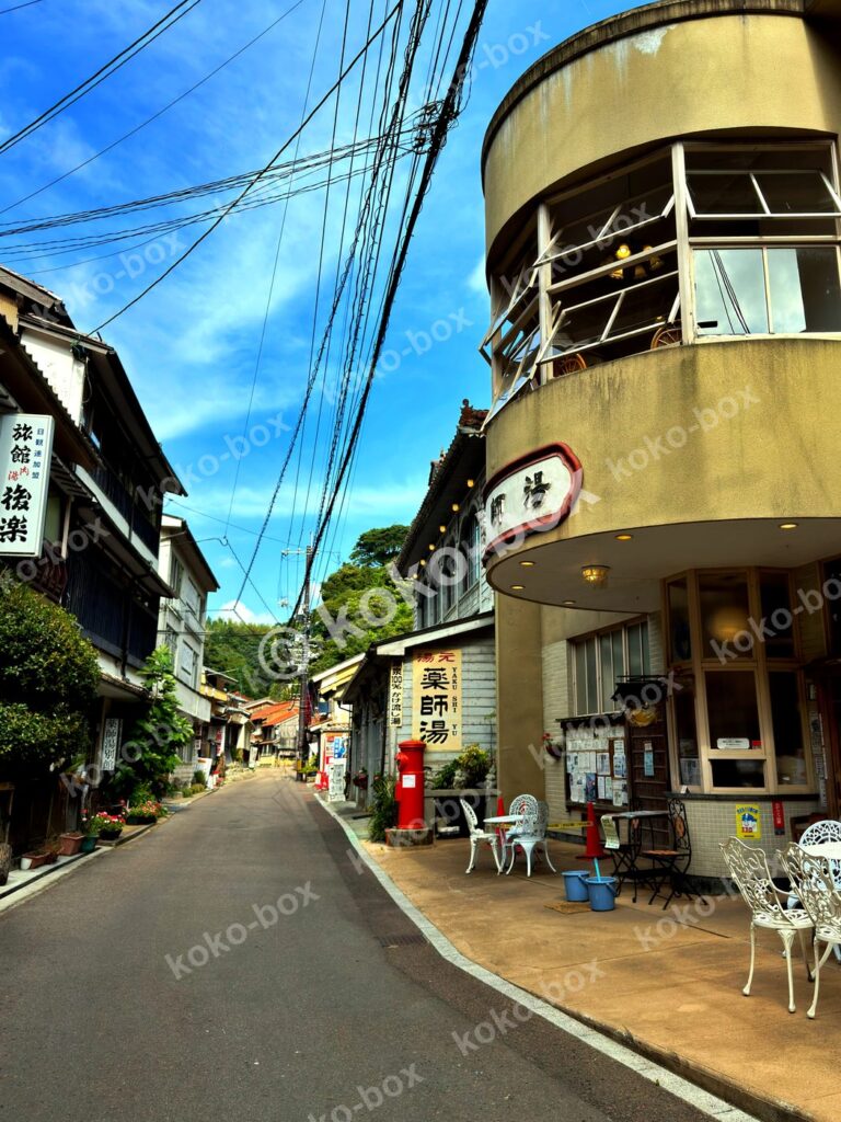 レトロな日本の温泉街の路地と薬師湯の建物、縦位置